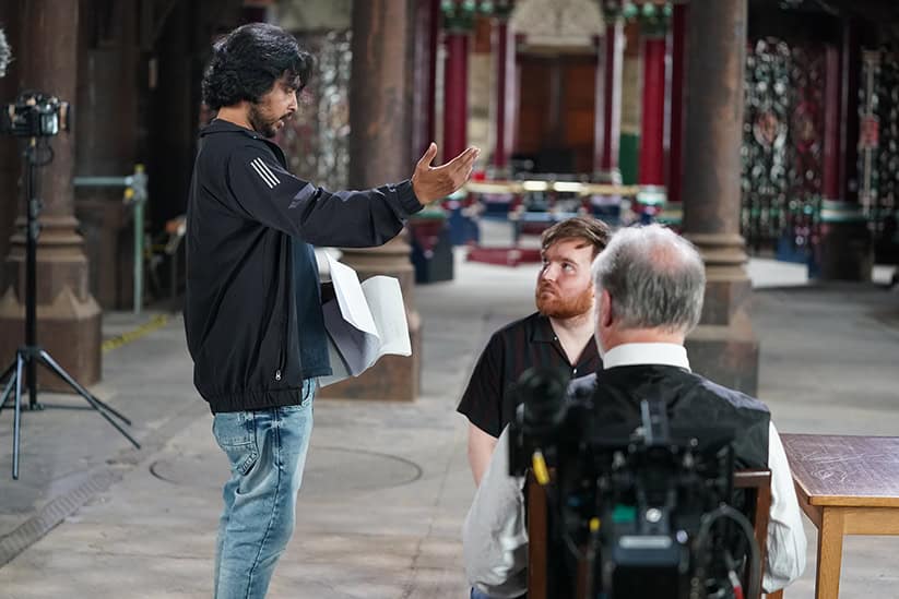 Behind the scenes of DEJA DREAM with director Mahmudul Hasan Jowel and lead actors Chris Cordell and Jack Deenay; Jowel standing and directing the others.