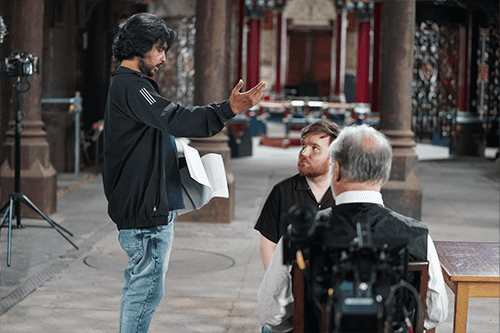Behind the scenes of DEJA DREAM with director Mahmudul Hasan Jowel and lead actors Chris Cordell and Jack Deenay; Jowel standing and directing the others.